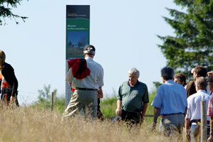 Eine Gruppe Wanderer vor einer Stele